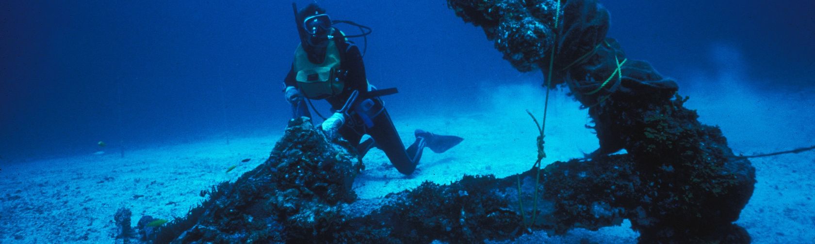 A diver beside one of the main anchors of the HMS Pandora shipwreck off the Queensland coast.